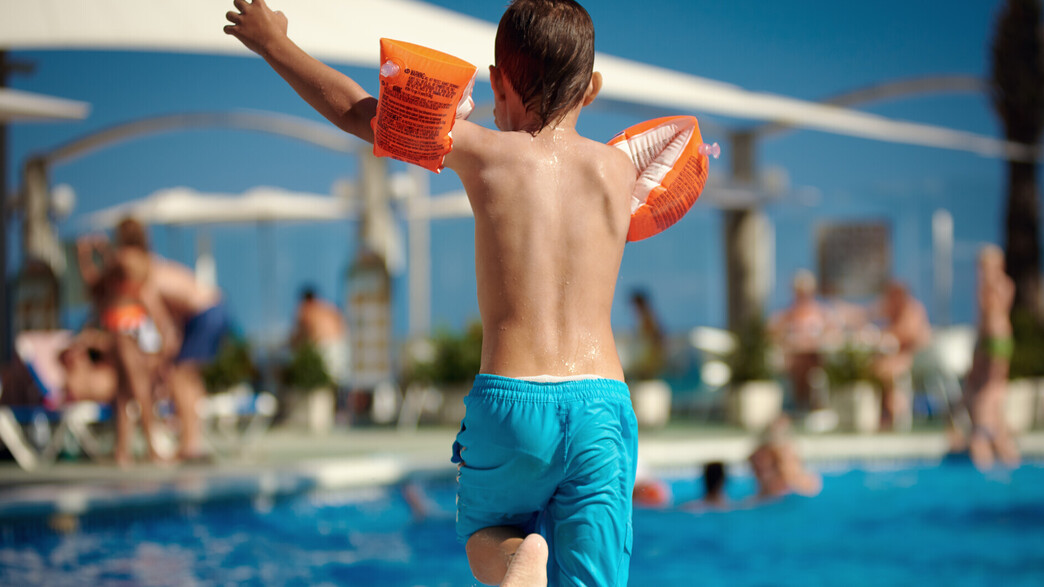 ילד קופץ לבריכת שחייה (צילום: ARTEM VOROPAI, shutterstock)