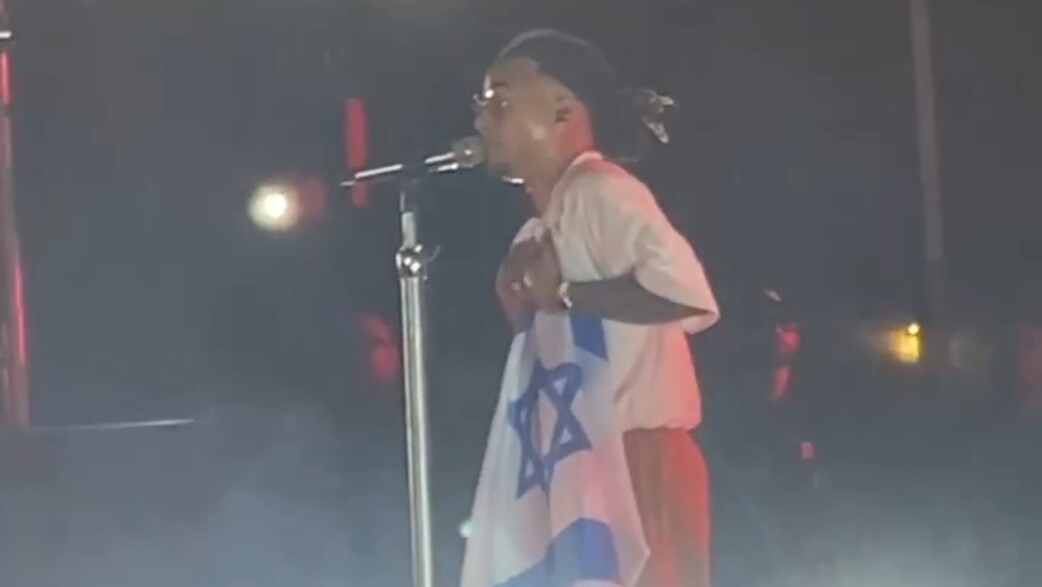 אוסונה מחזיק דגל ישראל בהופעה (צילום: מערכת mako מוזיקה)