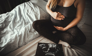 אישה בהריון ליד צילום אולטרסאונד (צילום: 123rf)