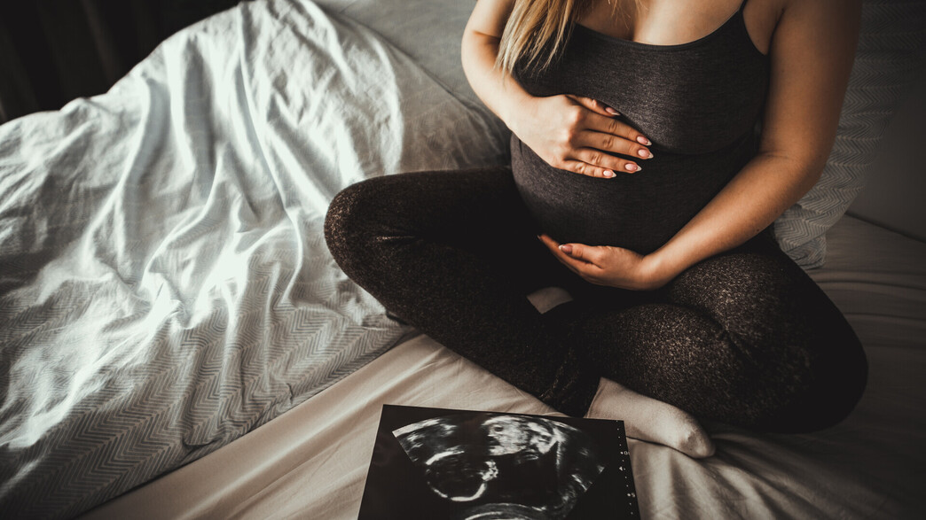 אישה בהריון ליד צילום אולטרסאונד