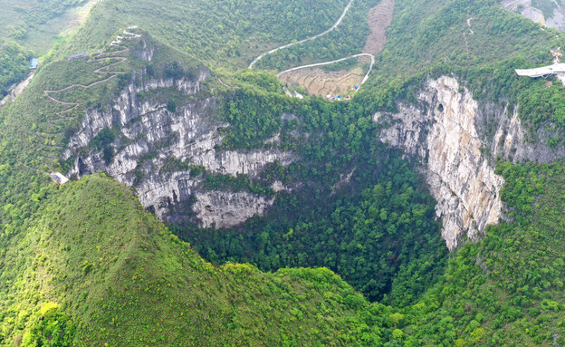 בולען בלב היערות בסין (צילום: Xinhua News Agency, Getty Images)