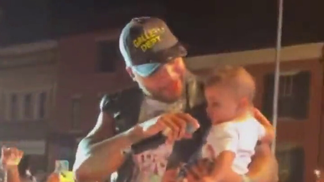 פלו-רידה מחזיק תינוק שהועבר אליו מהקהל בזמן הופעה