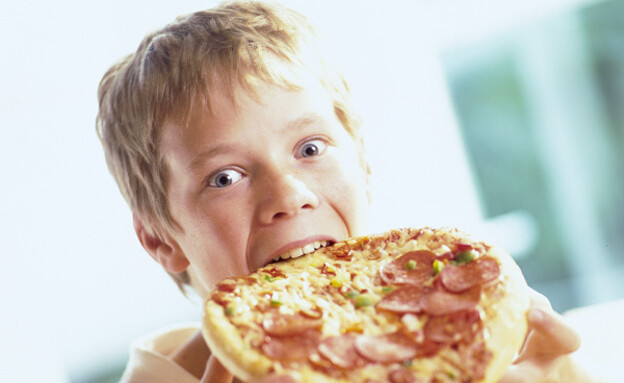 ילד בלונדיני אוכל פיצה עם נקניק (צילום: jupiter images)