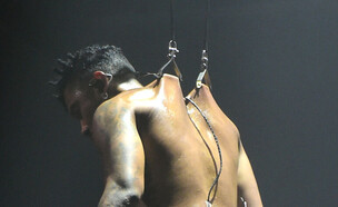 הזמר מיגל תלוי מקרסים הנעוצים בגבו (צילום: Vivien Killilea/Getty Images for Sony)