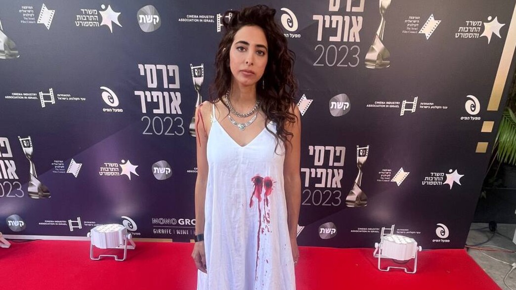 סמר קופטי עם שמלה ועליה "פצע ירי" במחאה