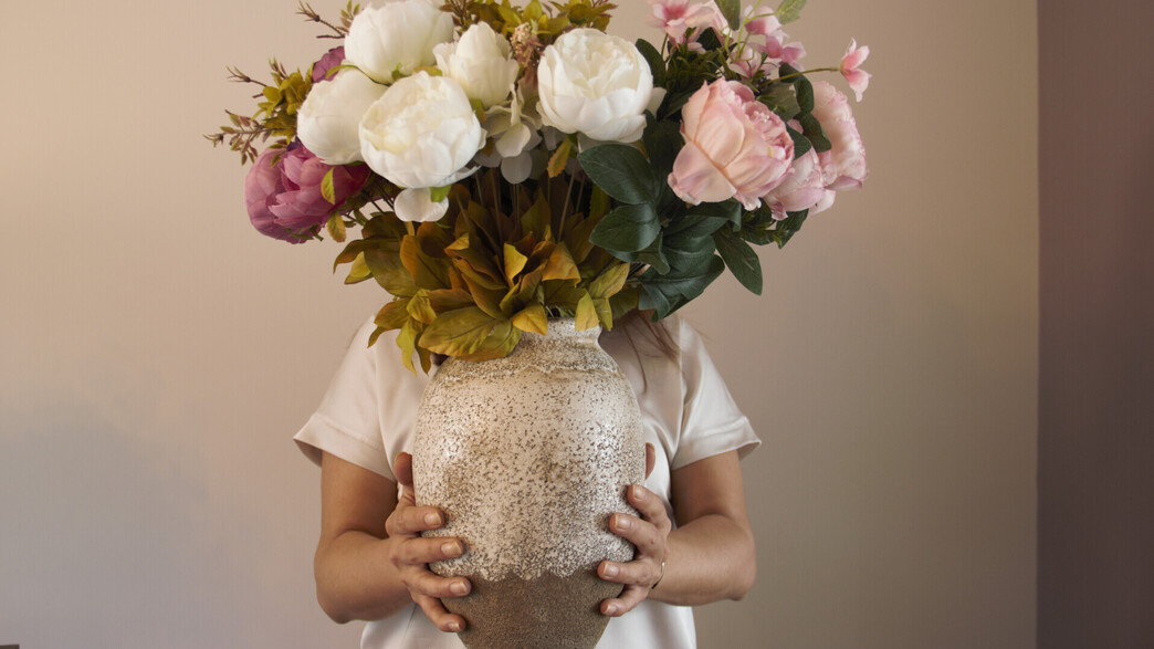 פרחים מלאכותיים, אישה מחזיקה אגרטל (צילום: MsmPhotography, SHUTTERSTOCK)