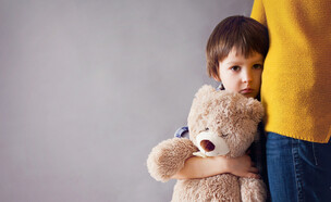 ילד עם דובי מקבל חיבוק  (צילום: Shutterstock)