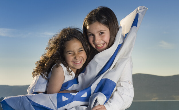 ילדים עטופים בדגל ישראל  (צילום: Noam Armonn, shutterstock)