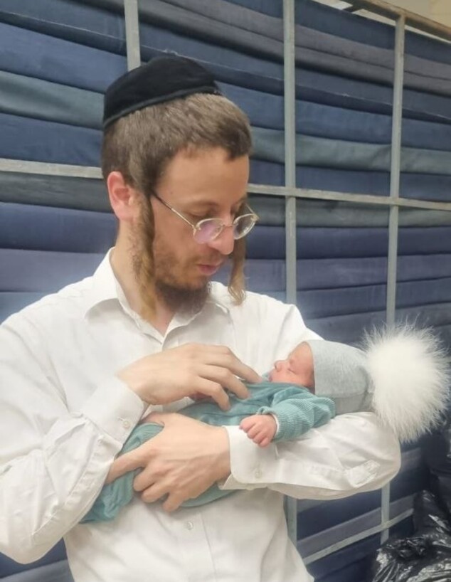 הרב בערל'ה רבינוביץ עם תינוק שנולד למפונים
