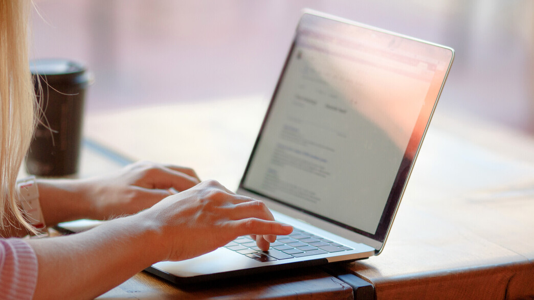 בחורה משתמשת בלפטופ, מקלידה על מחשב