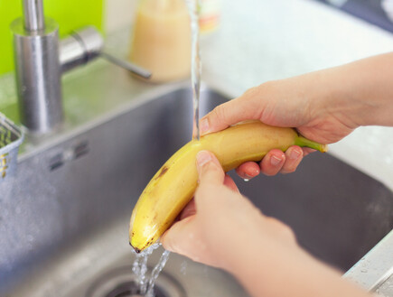 שטיפת בננות במים בכיור, בננה (צילום: StepanPopov, SHUTTERSTOCK)