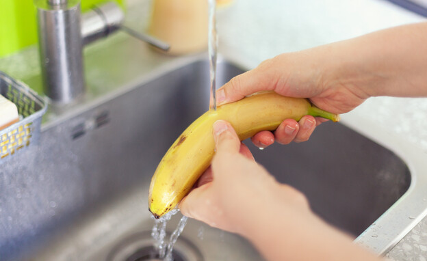 שטיפת בננות במים בכיור, בננה (צילום: StepanPopov, SHUTTERSTOCK)