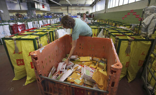 עובדת דואר ישראל ממינת חבילות במרכז חלוקה (צילום: ap)