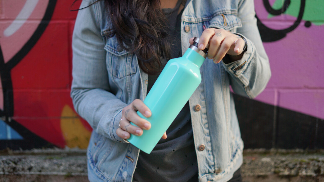 אישה מחזיקה בקבוק שתייה מנירוסטה (צילום: Jess Clark Creative, Shutterstock)