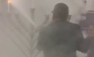 חבר הפרלמנט הפולני בראון מכבה חנוכייה עם מטף כיבוי (צילום: לפי חוק 27א׳ לזכויות יוצרים)