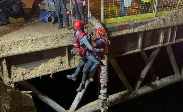 חילוץ פועל שנתקע בבטן האדמה באתר הרכבת הקלה בת"א (צילום: כבאות והצלה)