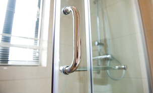 דלת זכוכית וידית של מקלחון (צילום:  hxdbzxy, SHUTTERSTOCK)