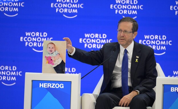 הנשיא הרצוג עם תמונת כפיר ביבס בכנס הכלכלי בדאבוס (צילום: עמוס בן גרשום לעמ‎, לע