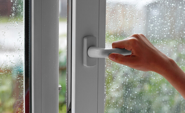 יד פותחת חלון ביום גשום (צילום: OB production, SHUTTERSTOCK)