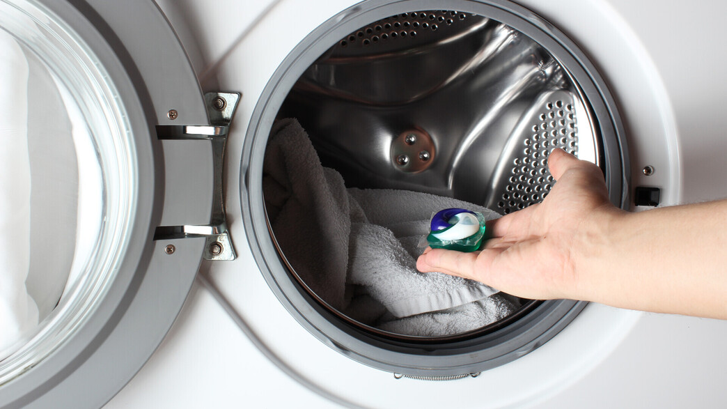 יד מכניסה קפסולת ג'ל כביסה למכונה יד מכניסה קפסולת ג'ל כביסה למכונה