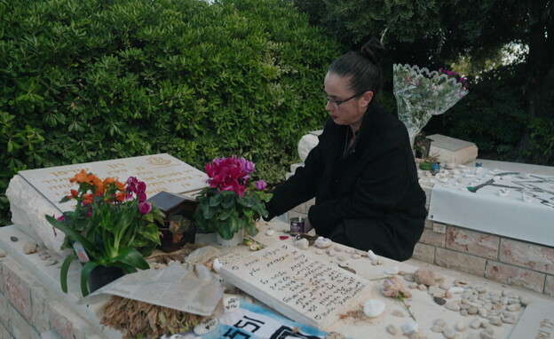 ד"ר מעין שרמן ליד הקבר של בנה סמל רון שרמן ז"ל (צילום: חדשות 12)