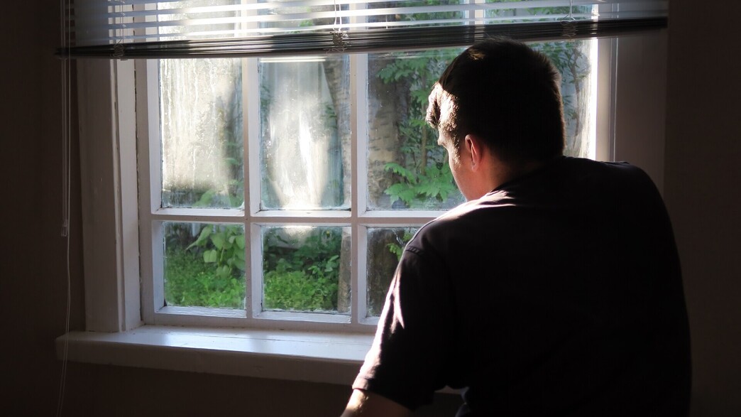 איש מודאג מסתכל מהחלון (צילום: Sabphoto, shutterstock)