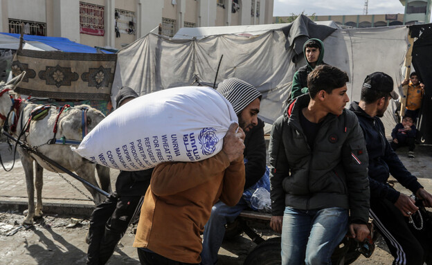 פלסטינים מקבלים סיוע מאונר"א (צילום: עבד רחים חטיב, פלאש 90)