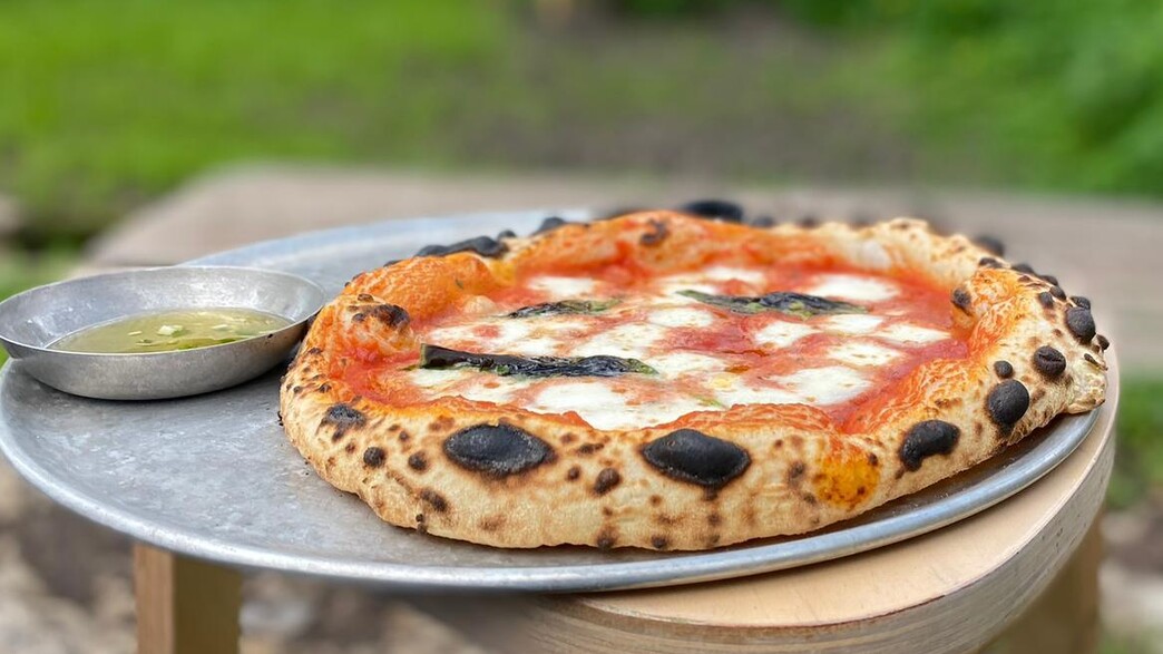 הפיצות מוגשות לצד צלוחית עם שמן זית מתובל בצ'ילי הפיצות מוגשות לצד צלוחית עם שמן זית מתובל בצ'ילי