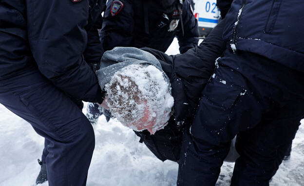 שוטרים רוסים עוצרים מפגין לאחר שראשו הוטח בשלג (צילום: רויטרס)