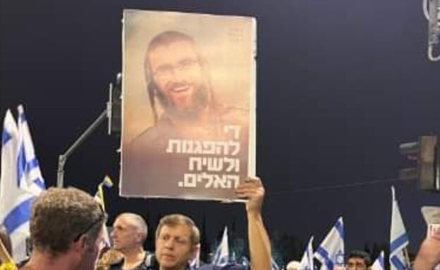 חגי לובר מחזיק את התמונה של בנו יהונתן ז"ל בהפגנות