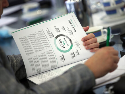 עיתונאי קורא את הדוח הפיננסי של חברת DFB (צילום: Alex Grimm, Getty Images)