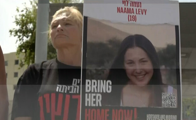 מפגינה מחזיקה שלט עם תמונה של החטופה נעמה לוי
