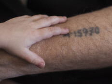 ילד שם את ידו על מספר האסיר של סבו