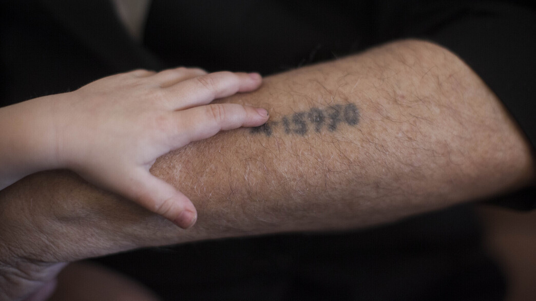 ילד שם את ידו על מספר האסיר של סבו (צילום: יונתן סינדל, פלאש 90)