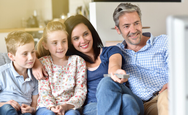 משפחה צופה בטלוויזיה בערב  (צילום: goodluz, shutterstock)