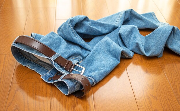 מכנסי ג'ינס זרוקים על רצפת פרקט, בגדים על הרצפה (צילום: Toru Kimura, SHUTTERSTOCK)