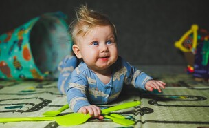 תינוק בן 7 חודשים משחק עם צעצועי גומי (צילום: DS Tkachuk, shutterstock)