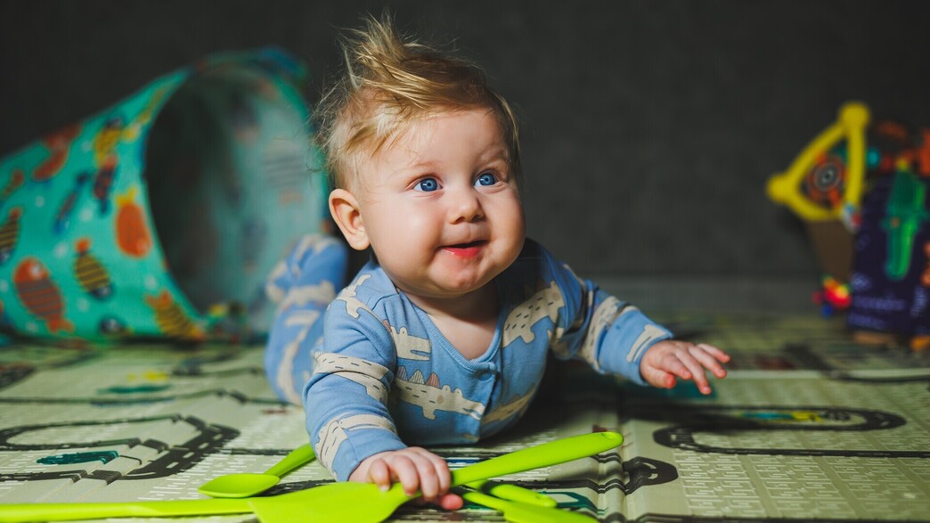 תינוק בן 7 חודשים משחק עם צעצועי גומי (צילום: DS Tkachuk, shutterstock)