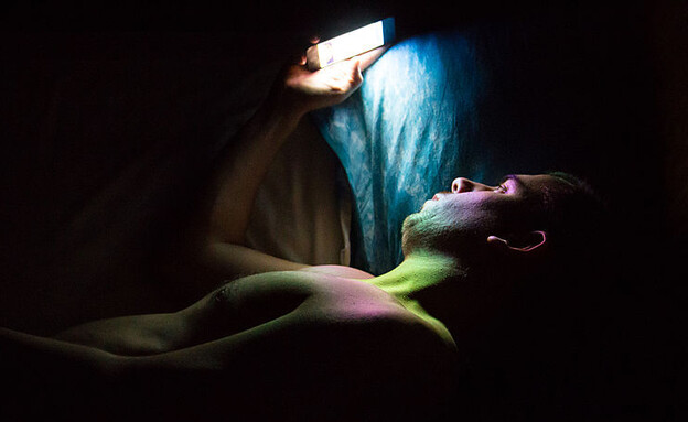 שימוש בסמארטפון במיטה (צילום: Artur Debat/Getty Images)