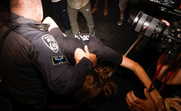שוטר תופס באלימות בראשה של מפגינה  (צילום: גיל לוין)
