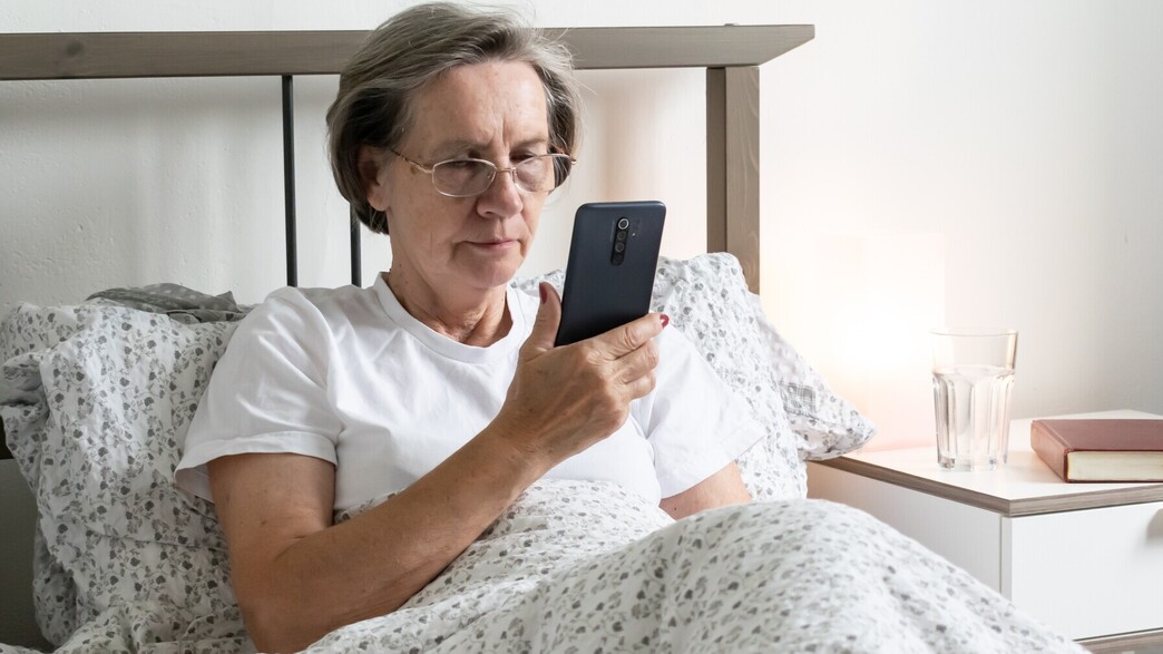 אישה מבוגרת מחזיקה סמארטפון, אילוסטרציה (צילום: metodej, Shutterstock)