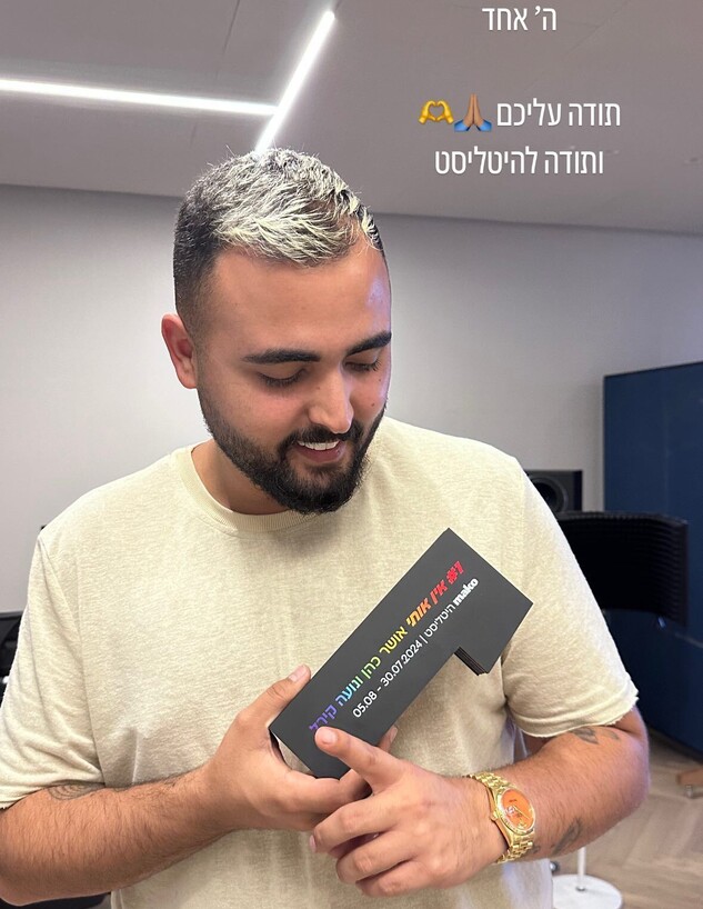 אושר כהן עם הפסלון של היטליסט