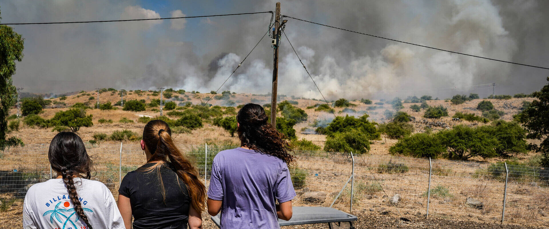 נערות צופות בשריפה שפרצה בעקבות ירי טילים ליד קיבוץ שמיר (צילום: אייל מרגולין, פלאש 90)