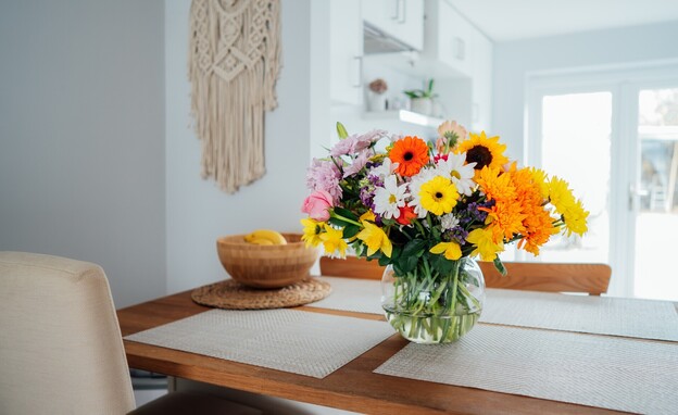 סידור פרחים על שולחן אוכל (צילום: Okrasiuk, SHUTTERSTOCK)