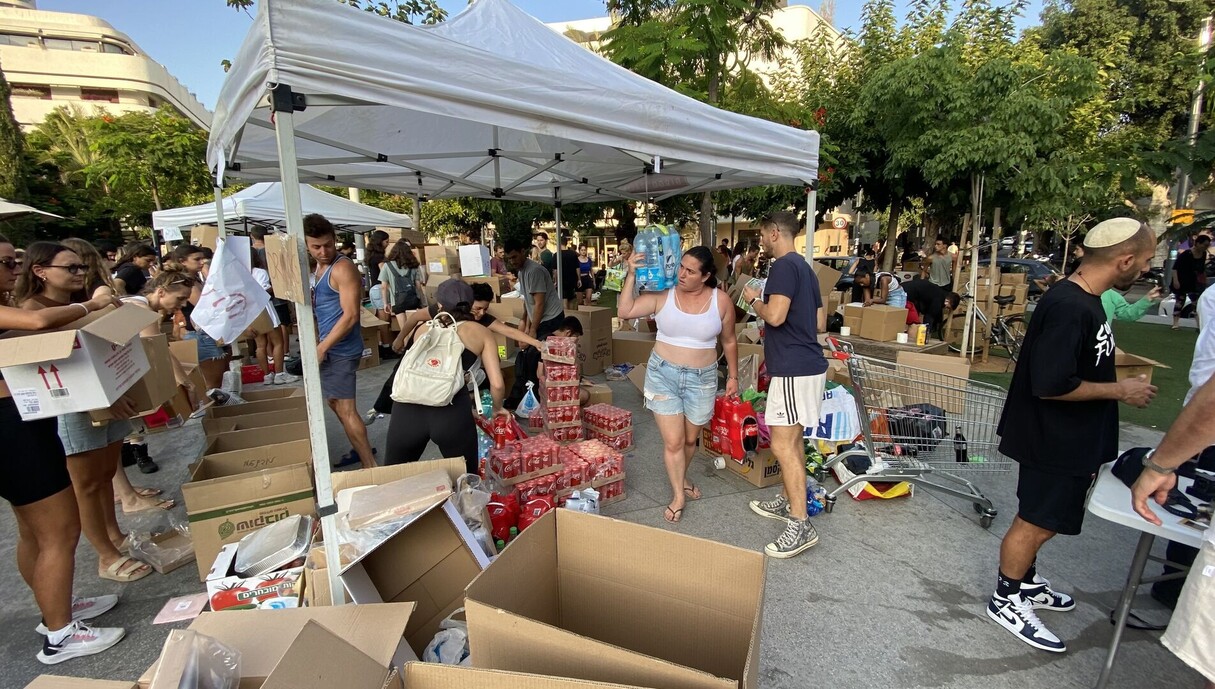 אזרחים אורזים מצרכים חיוניים לחיילים בכיכר דיזינגוף (צילום: ליאור גרינברג)