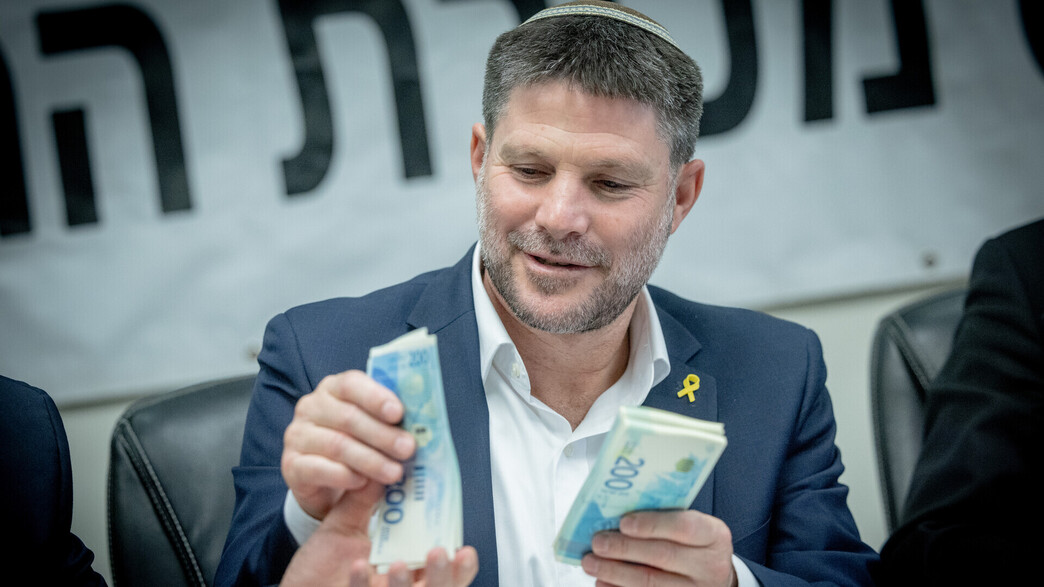 שר האוצר בצלאל סמוטריץ' עם שטרות כסף במעמד מכירת ה