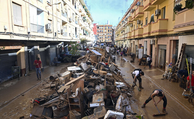 מתנדבים מנקים את ולנסיה רחובות בוץ (צילום: JOSE JORDAN , getty images)