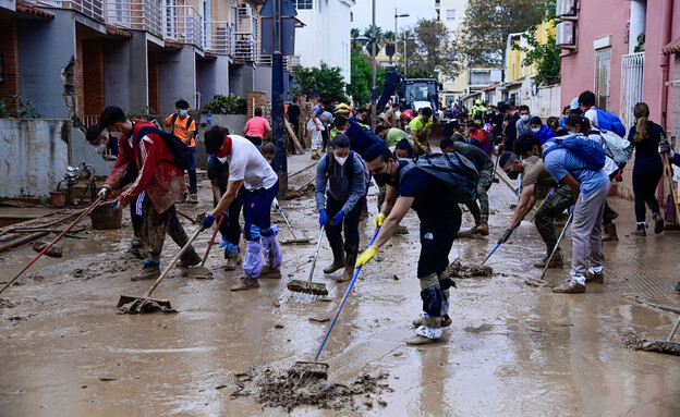 מתנדבים ולנסיה רחובות בוץ (צילום: JOSE JORDAN, getty images)