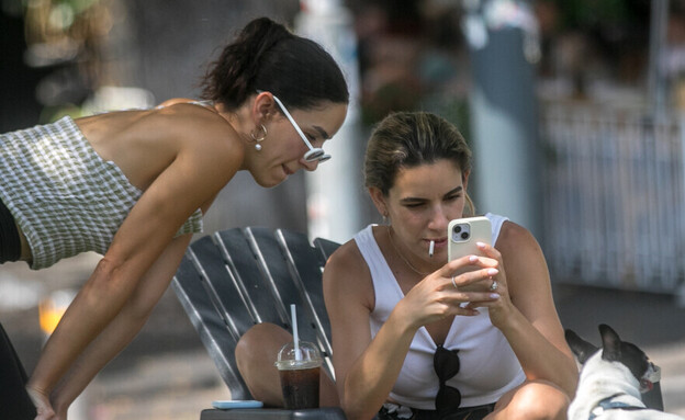 נשים מצלמות תמונה בסלולרי ברחוב דיזנגוף בתל אביב (צילום: מרים אלסטר, פלאש 90)