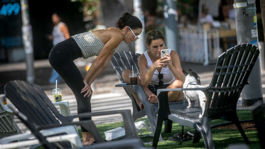 נשים מצלמות תמונה בסלולרי ברחוב דיזנגוף בתל אביב